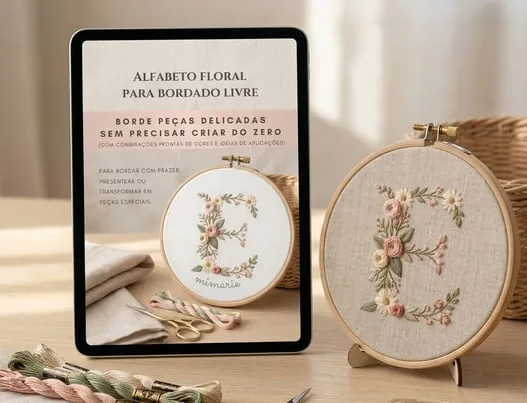 Bastidor com letra floral bordada ao lado de quadrinho decorativo