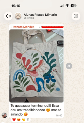 Aluna mostrando bordado finalizado no grupo